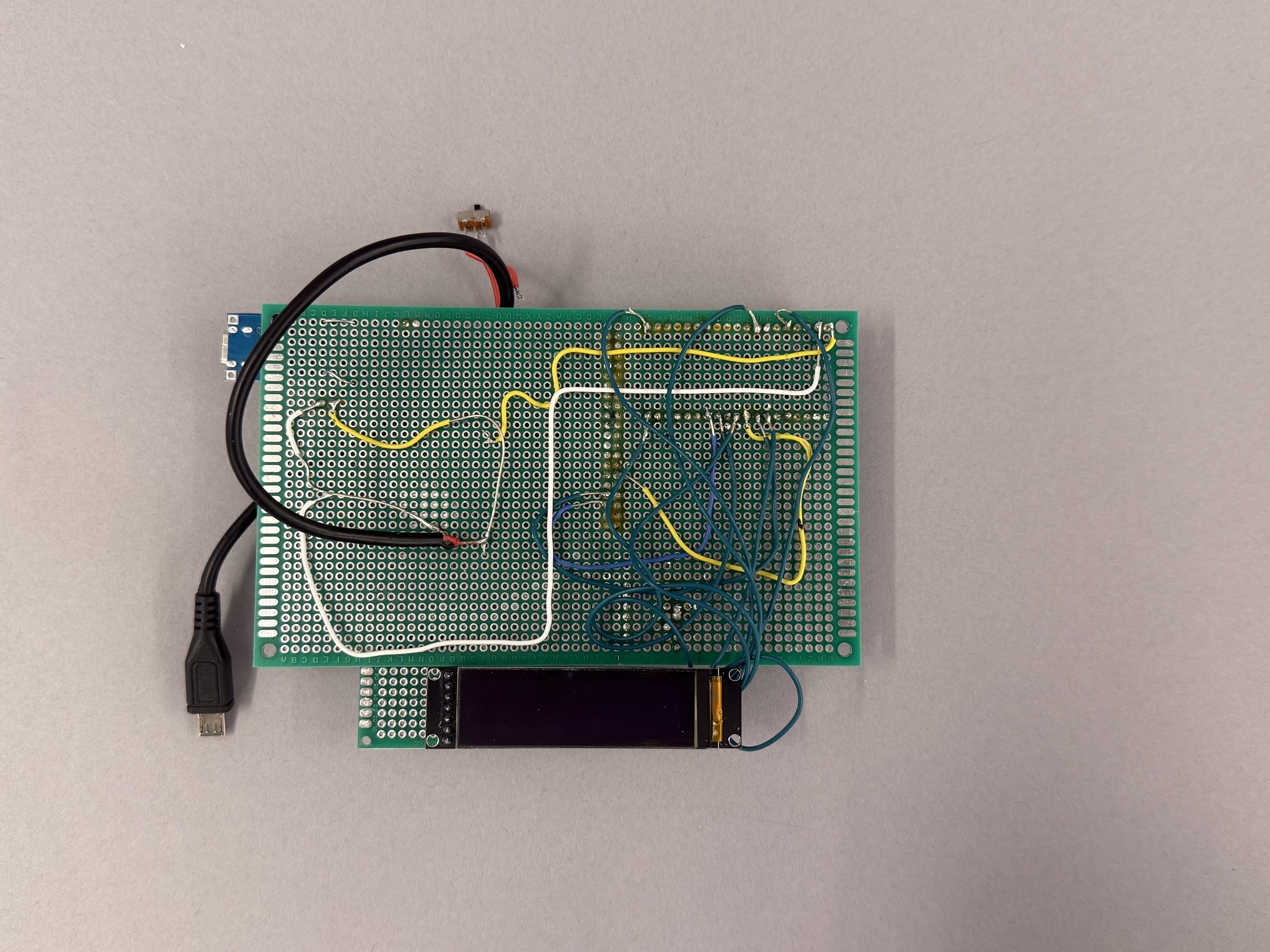 MonoScribe circuit prototype with a perfboard, OLED display, wiring, power connection, and switch