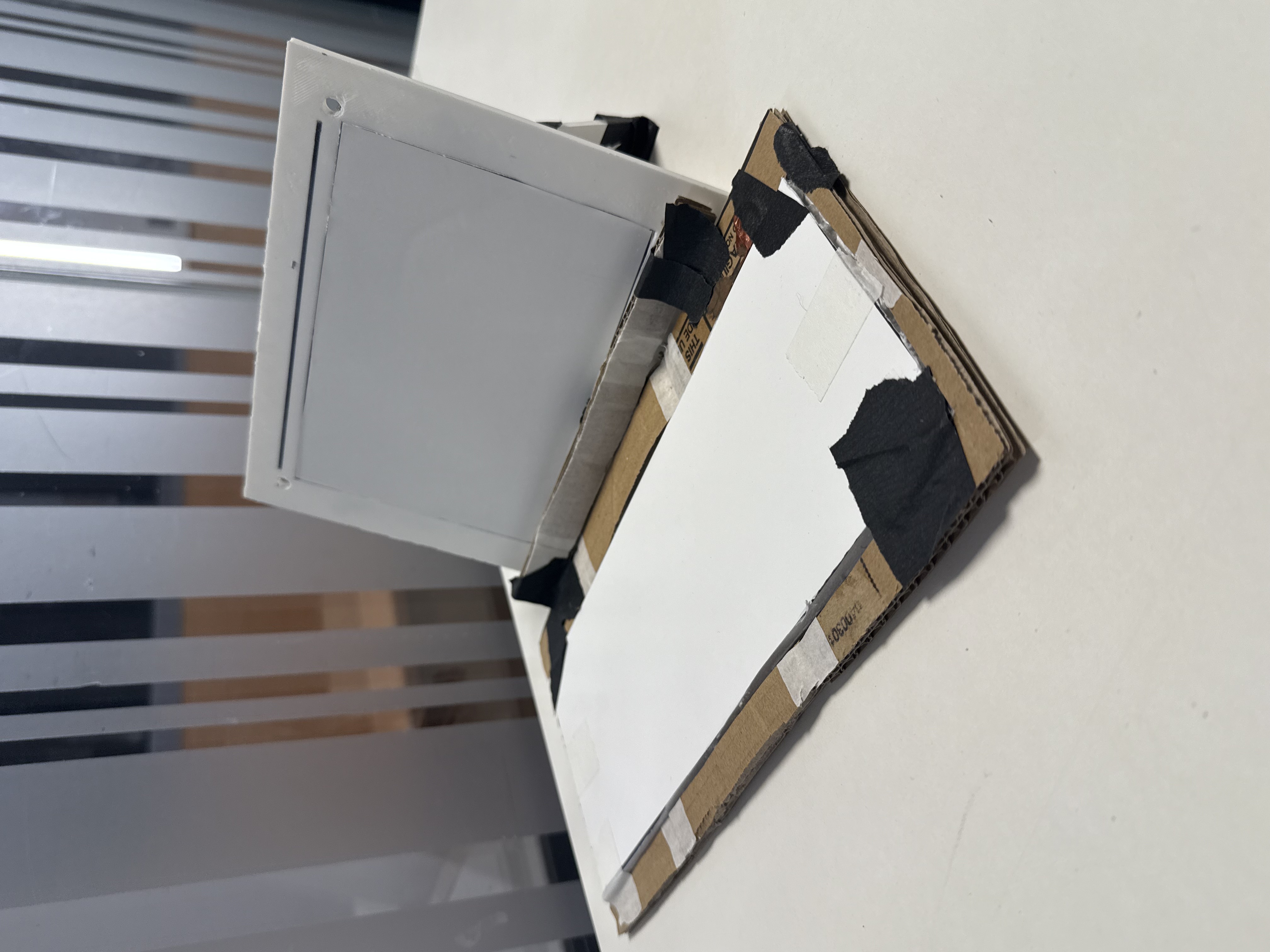 Early cardboard MonoScribe prototype with a screen frame and keyboard base